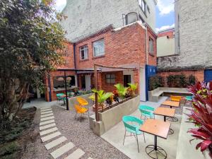 a patio with tables and chairs in front of a building at Trip Monkey Chapinero in Bogotá