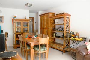 uma sala de jantar com uma mesa e mobiliário em madeira em Casa Pau Brasil em Arraial d'Ajuda