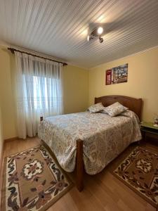 1 dormitorio con cama y ventana en Casa Violeta en Águeda