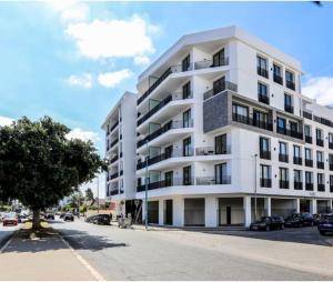 un bâtiment blanc avec des voitures garées devant lui dans l'établissement super appartement with parking c4, à Casablanca