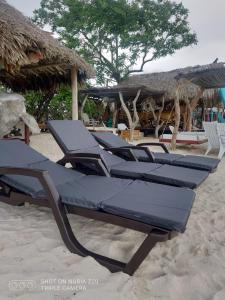uma fila de espreguiçadeiras na praia em Cabaña en Playa Blanca, Barú In house beach em Barú