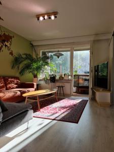 uma sala de estar com um sofá e uma mesa em Paradise apartment em Vantaa