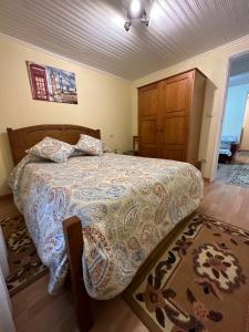 a bedroom with a large bed with a wooden headboard at Casa Violeta in Águeda
