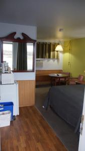 una camera con letto, tavolo e specchio di Robyn's Motel a Peterborough