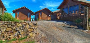 a house with a stone wall next to a building at Pousada Morada da Serra in Cambará