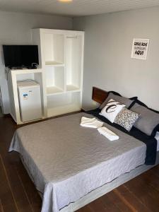 um quarto com uma cama grande e uma televisão. em Gravatá beach flats em São José da Coroa Grande