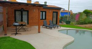 ein Haus mit einer Terrasse und einem Pool in der Unterkunft Cabaña con piscina, urb. privada. Playa. in Carrió