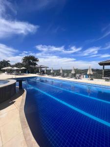 a large blue swimming pool with umbrellas at Paraty Hotel Fazenda & Spa in Ibiúna