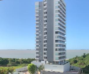 a tall apartment building with a view of the ocean at Biarritz temporadalitoranea in São Luís