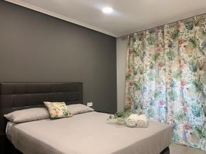 um quarto com 2 camas e uma cortina floral em Apartamento Deluxe, 4 habitaciones, Parking em Madri