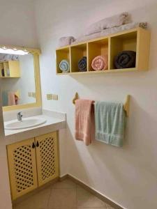 a bathroom with a sink and a mirror and towels at Excelente apartamento en Las Terrenas, Playa Punta Popi. in Las Terrenas