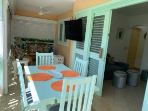 a dining room with a table and chairs and a television at Excelente apartamento en Las Terrenas, Playa Punta Popi. in Las Terrenas