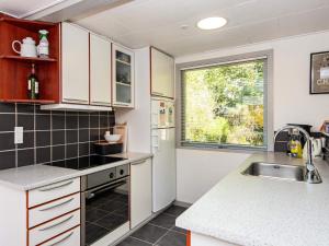 a kitchen with white cabinets and a sink and a window at 6 person holiday home in Ebeltoft in Ebeltoft