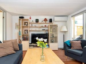 a living room with a vase of flowers on a table at 6 person holiday home in Ebeltoft in Ebeltoft