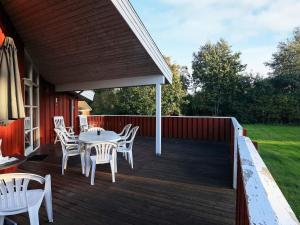 um deque de madeira com uma mesa e cadeiras em 10 person holiday home in Jerup em Jerup