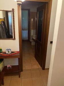 ein Bad mit einem WC, einem Spiegel und einer Tür in der Unterkunft Casa Vacanze AURELIA in Biandronno