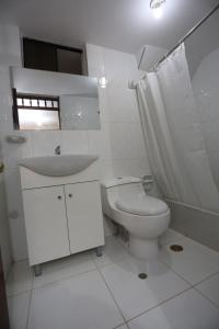 Baño blanco con aseo y lavamanos en Witobi Hostal en Cajamarca