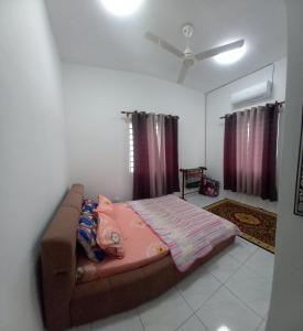 a bed in a room with a ceiling fan at Homestay D'Mama Īfor mūslimĪ in Tanjung Malim