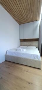 - une chambre avec un grand lit et des placards blancs dans l'établissement Avalona Apartment 1, à Vlorë