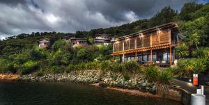 una casa en una colina junto a un cuerpo de agua en Bay of Many Coves en Arthur's Bay