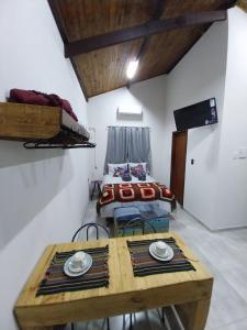 um quarto com uma mesa, um sofá e uma cama em Sitio148 Hospedaria em Penedo