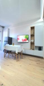 - un salon avec une table et une télévision murale dans l'établissement Avalona Apartment 1, à Vlorë