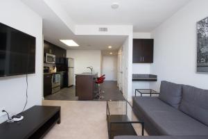 sala de estar con sofá gris y cocina en Nice 2BR Pentagon City Apartment, en Arlington
