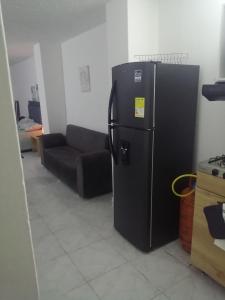 a black refrigerator in a living room with a couch at San Diego aparta estudios in Medellín