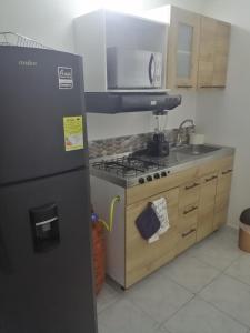 a kitchen with a refrigerator and a stove top oven at San Diego aparta estudios in Medellín