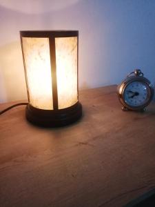 a lamp on a table next to a clock at San Diego aparta estudios in Medellín