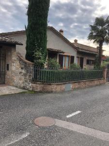 une maison avec un arbre et une clôture de fer dans l'établissement La Poderina, à Monteriggioni