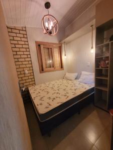 ein kleines Schlafzimmer mit einem Bett in einem Zimmer in der Unterkunft Novo lar Garopaba Terraço in Garopaba