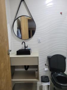 Novo lar Garopaba Terraço في غاروبابا: حمام مع حوض ومرحاض ومرآة