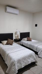 - 2 lits installés l'un à côté de l'autre dans une chambre dans l'établissement Casa equipada Cd Valles, à Ciudad Valles