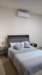 a bedroom with a large bed with blue pillows at Casa equipada Cd Valles in Ciudad Valles
