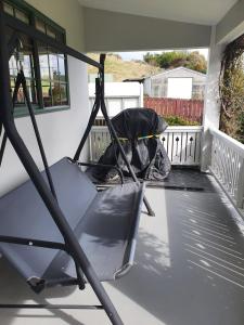 a porch with a hammock on a house at Ludstone Villa - A charming family home in Kaikoura