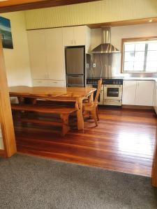 a large kitchen with a wooden table and a stove at Ludstone Villa - A charming family home in Kaikoura