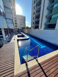 a swimming pool on the side of a building at 3 SUITES Vista Mar - WI-FI, PISCINA, SAUNA, ACADEMIA, GARAGEM 2 CARROS in Ilhéus