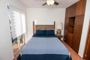 Schlafzimmer mit einem blauen Bett und einem Deckenventilator in der Unterkunft Your Cabo Penthouse Escape Walk to Sand & Sea! in Cabo San Lucas