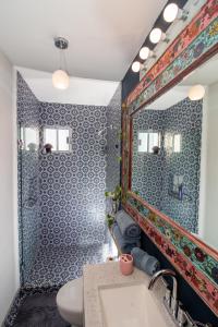 ein Badezimmer mit Dusche, Waschbecken und Spiegel in der Unterkunft Your Cabo Penthouse Escape Walk to Sand & Sea! in Cabo San Lucas