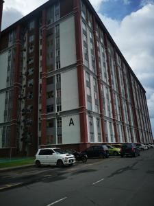 a large red and white building with cars parked in front at Putatan Platinum Apartment with Pool in Kota Kinabalu