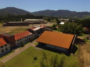 una vista aérea de un edificio escolar con techo rojo en Pousada Divino Oleiro - Gov. Celso Ramos, en Governador Celso Ramos