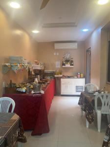 a kitchen with a red counter and a table with chairs at Pousada Ferreira III in Aracaju