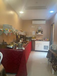 a kitchen with a red table with food on it at Pousada Ferreira III in Aracaju