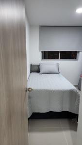 a bedroom with a bed and a wooden door at APARTAMENTO DE LUJO EN LA MILLA DE ORO DE IBAGUÉ, COLOMBIA. in Ibagué