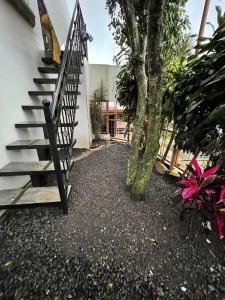 una escalera que conduce a una casa con un árbol en Elegante Casa de 4 Habitaciones a Solo 15 Minutos del Corazón de la Ciudad, en San José