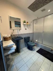 ein Badezimmer mit einem blauen WC und einem Waschbecken in der Unterkunft Elegante Casa de 4 Habitaciones a Solo 15 Minutos del Corazón de la Ciudad in San José