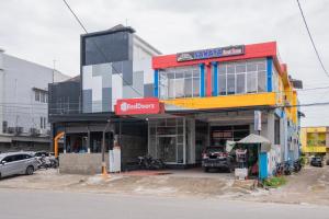 a building on the side of a street with cars parked outside at RedDoorz Syariah near RS Mata Padang in Padang