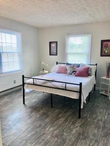 um quarto com uma cama grande e 2 janelas em Trestle Creek Farm- farmhouse suite em Bloomington
