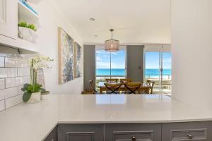 una cucina con vista sulla sala da pranzo e sull'oceano di Regency Court Absolute Beachfront a The Entrance